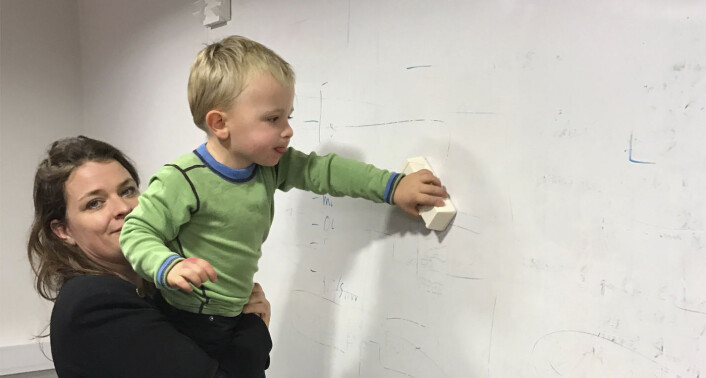 Åste holder sønnen, som hvisker ut notatene på en whiteboard. Foto: Privat Åste holder sønnen, som hvisker ut notatene på en whiteboard. Foto: Privat