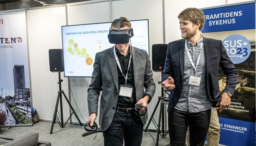 Ingeniør Kristoffer Tungland (til høyre) guider besøkende rundt i VR-studioet. Her inne kan VR-brukerne møte avatarene til andre mennesker som besøker modellen - fra et helt annet sted i landet. Foto: COWI Ingeniør Kristoffer Tungland (til høyre) guider besøkende rundt i VR-studioet. Her inne kan VR-brukerne møte avatarene til andre mennesker som besøker modellen - fra et helt annet sted i landet. Foto: COWI