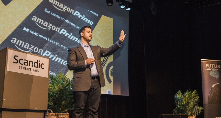 Andrew Arruda på scenen under Future Lawyer. Han holder opp fire fingre for å vise hvor mange ganger gjennomsnittspersonen er innom en produktannonse på Amazon før de bestiller det. Foto: Benedicte Tandsæther-Andersen Andrew Arruda på scenen under Future Lawyer. Han holder opp fire fingre for å vise hvor mange ganger gjennomsnittspersonen er innom en produktannonse på Amazon før de bestiller det. Foto: Benedicte Tandsæther-Andersen