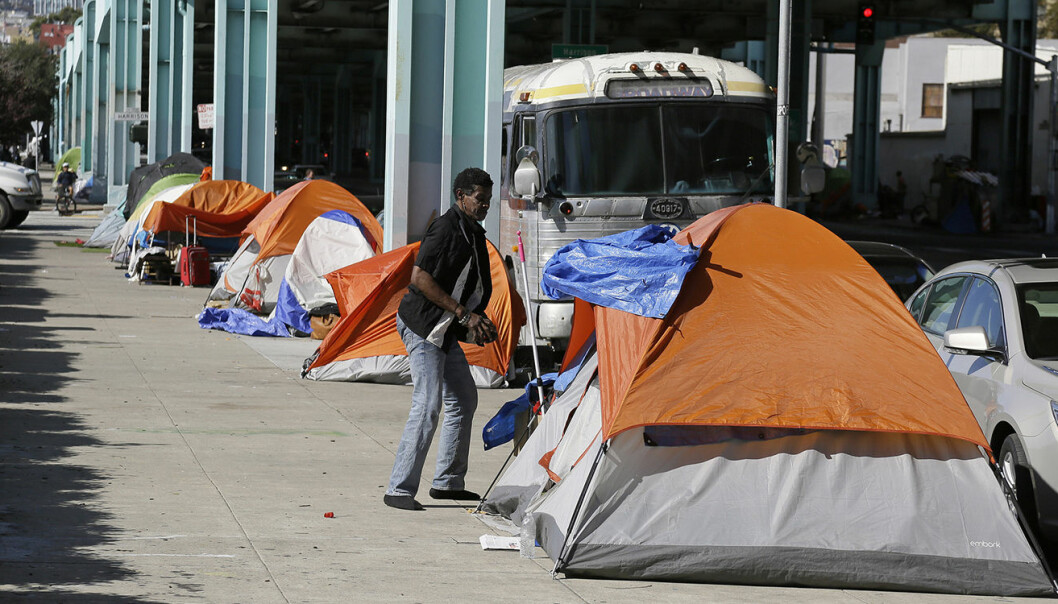 En hjemløs mann står utenfor teltet sitt på Division Street i San Francisco. Byen sliter med lønnsulikhet, og dette skal være en del av årsaken til at man har valgt å stemme over høyere skatter for de rikeste. Foto: AP Photo/Eric Risberg, File