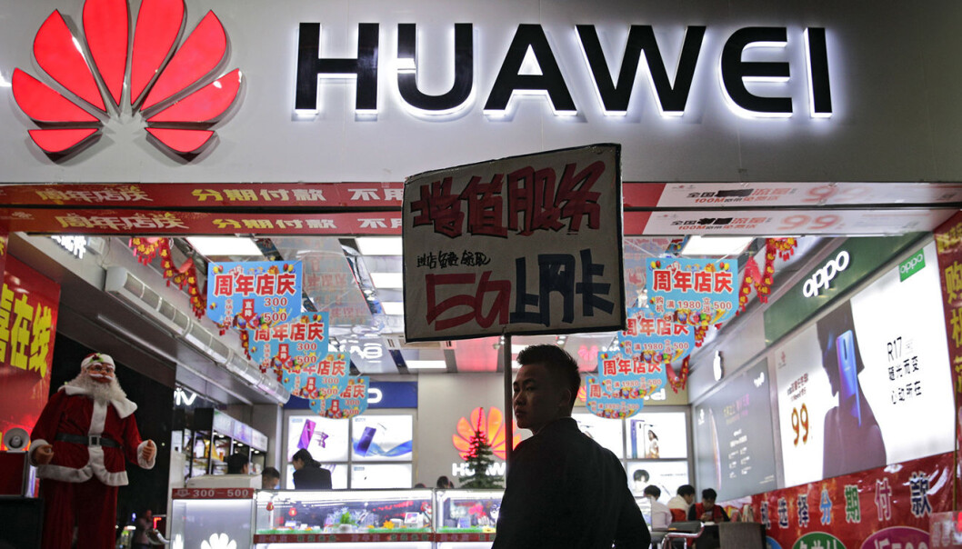 En ansatt holder et skilt med reklame for Huawei 5G-internettjenester, utenfor en mobilbutikk i Shenzhen i det sørlige Kinas Guangdong province. Foto: AP Photo/Andy Wong En ansatt holder et skilt med reklame for Huawei 5G-internettjenester, utenfor en mobilbutikk i Shenzhen i det sørlige Kinas Guangdong province. Foto: AP Photo/Andy Wong