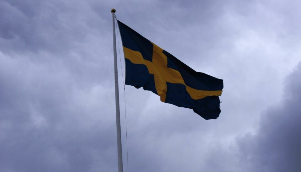 Sveriges flagg og mørke skyer.