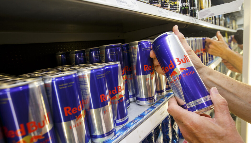 Kunde plukker energidrikk i en hylle.