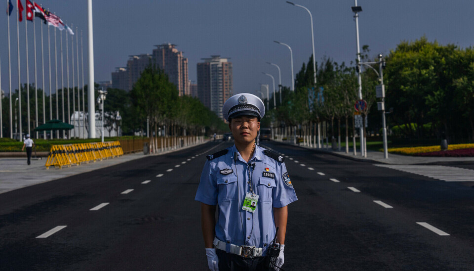 En politimann står vakt ved en konferanse i Shanghai i september 2025.