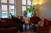 Lasse Smedsvig sammen med foreldrene og katten. Moren forklarer hvordan huset var inndelt før - for hundre år siden bodde det 29 mennesker der.