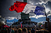 Stort fransk flagg over en tett folkemengde foran et monument i Paris under en demonstrasjon.