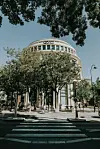 Buet bygning i Paris bak trær, med fotgjengerfelt og gatelykter i forgrunnen.