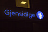 Belyst Gjensidige-logo på en mørk fasade i Oslo.